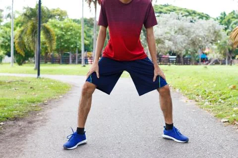 Young man runner warm up before run - workout concept Stock Photos
