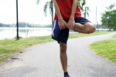 Young man runner warm up before run - workout concept Stock Photos