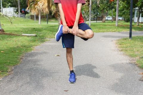 Young man runner warm up before run - workout concept Stock Photos