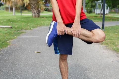 Young man runner warm up before run - workout concept Stock Photos