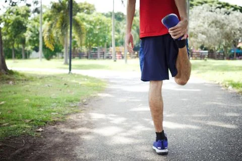 Young man runner warm up before run - workout concept Stock Photos