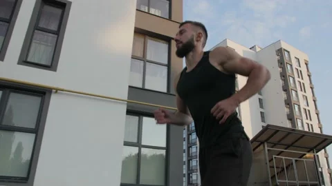 Young man is running among the high-rise buildings. Video stock 150176312