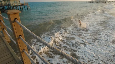 Young man running and jumping into the waves of the sea, resort Stock Footage 51253232