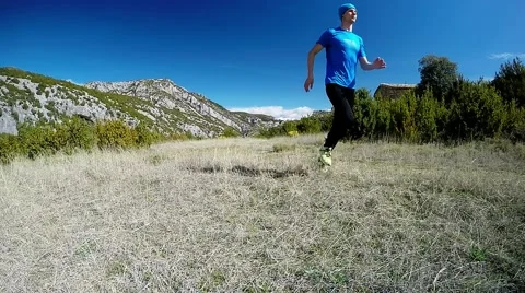 Young man running away on mountain trail in alpine pasture Stock Footage 48900799