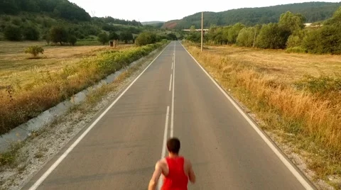 Young Man Running On a Beautiful Sunset Drone View Stock Footage 68884064