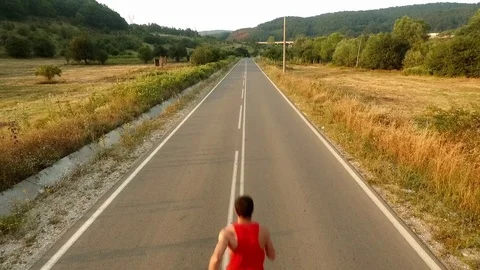 Young Man Running On a Beautiful Sunset Drone View Stock Footage 69718698