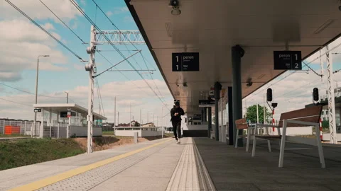 Young Man Running to Catch Train on Empty Platform Stock Footage 309077835