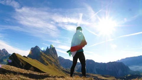 Young man in running clothes standing on mountain peak raising italian flag to Video stock 122102166