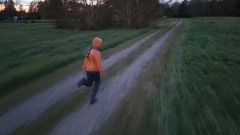 Young Man Running from Drone and Falling in Rural Area Stock Footage 326168093