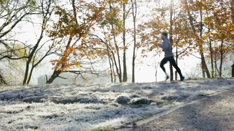 Young man running during cold winter morning in park Stock Footage 57820201