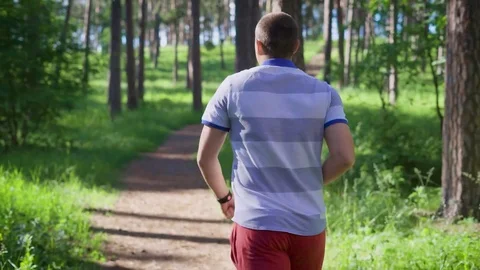 Young man running in the forest. Sport and healthy lifestyle. Summer time Stock Footage