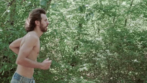 Young man running in the forest,into the wild- sport,nature Stock Footage 95594253