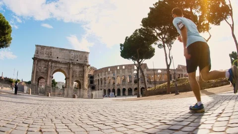 Young man running jogging in front of Colosseum and Arch of Constantine at Stock Footage 119483376
