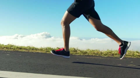 Young Man Running on Mountain Road at Sunset Above the Clouds. Slow Motion HD Stock Footage 59810666