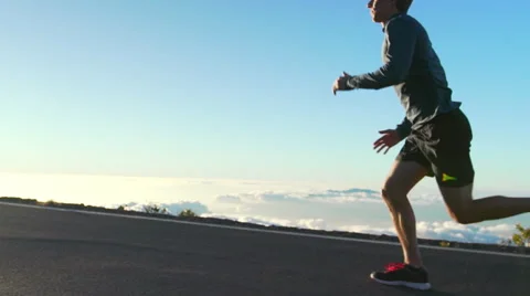 Young Man Running on Mountain Road at Sunset Above the Clouds. Slow Motion HD Stock Footage 59822649