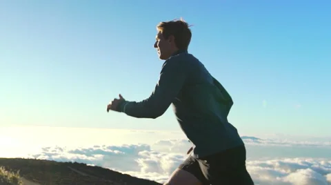 Young Man Running on Mountain Road at Sunset Above the Clouds. Slow Motion HD Stock Footage 59822903