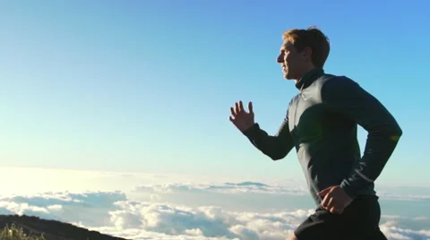 Young Man Running on Mountain Road at Sunset Above the Clouds. Slow Motion HD Stock Footage 59823015