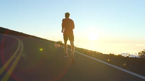 Young Man Running on Mountain Road at Sunset Above the Clouds. Slow Motion HD Stock Footage 59824079
