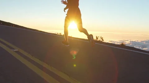 Young Man Running on Mountain Road at Sunset Above the Clouds. Slow Motion HD Stock Footage 59824086