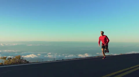 Young Man Running on Mountain Road at Sunset Above the Clouds. Slow Motion HD Stock Footage 59825536