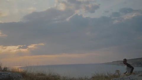 Young Man Running on Mountain Road at Sunset Above the Clouds. Slow Motion HD Stock Footage 79411448