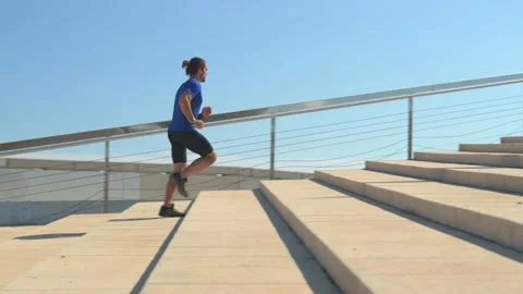 Young man running outdoors up a flight of stairs. Sports concept. Stock Footage 229727776