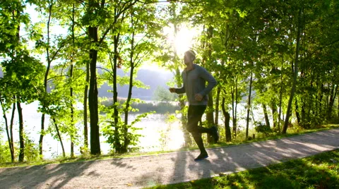 Young man running in park  during sun rise – slow motion Stock Footage 55084814
