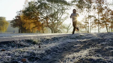 Young man running in park during sunny winter morning Stock Footage 57818951