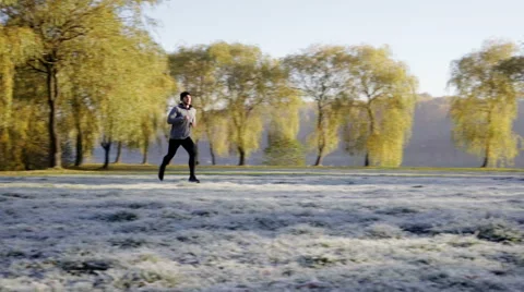 Young man running at park during cold autumn morning Stock Footage 57820082