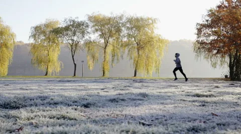 Young man running in park during cold winter morning Stock Footage 57820320