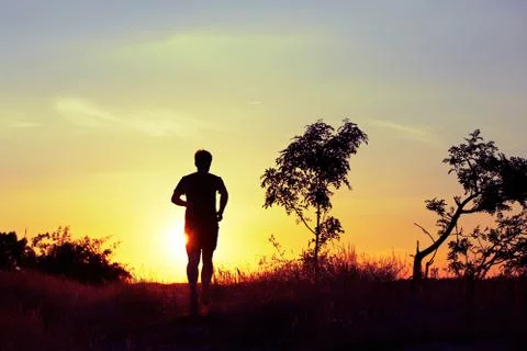 Young man is running at the sunset Foto stock