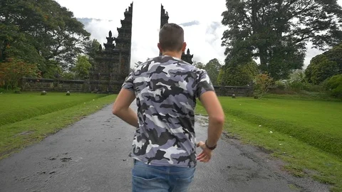 Young man running through Candi Bentar gate in slow motion Stock Footage 85618294
