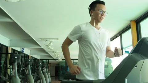 Young man running on treadmill Stock Footage 89372547