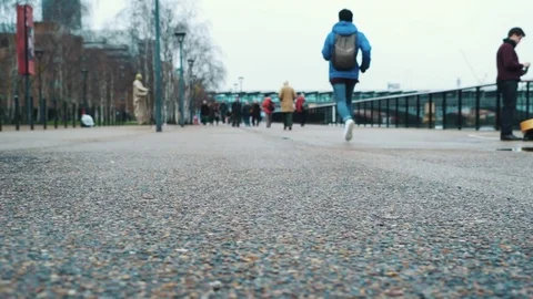 A young man running to work late on concrete during a cold winter weather Stockbeeldmateriaal 75928317