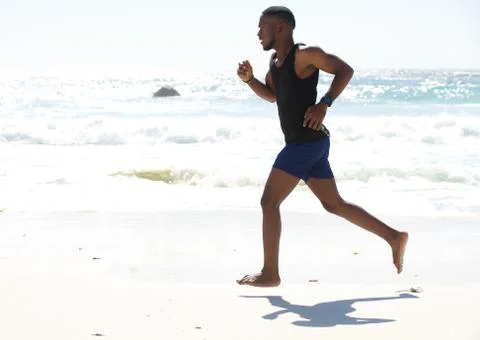 Young man running work out at the beach Stock Photos