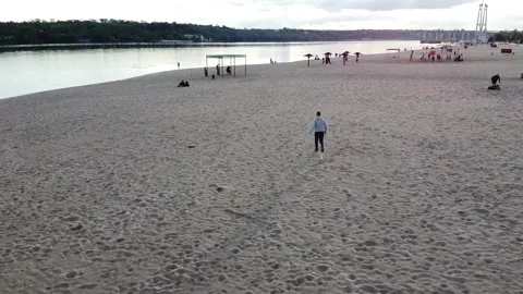 Young man runs along the beach cool weather Stock Footage 131781940