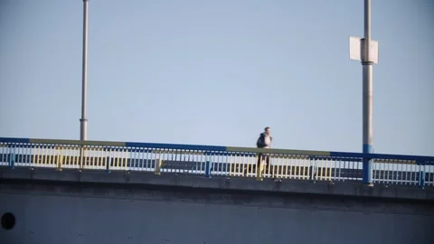 Young man runs on the bridge Stock Footage 128326220