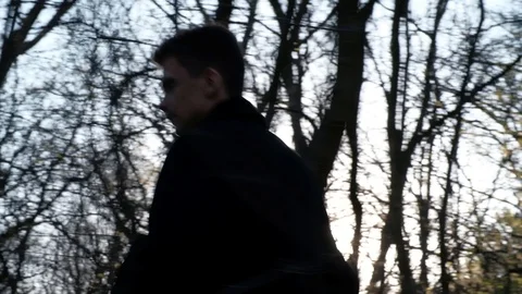A young man runs dodging from the branches of trees in the forest. Sun rays Stock Footage 89348778