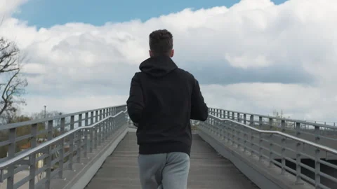 A young man runs forward. The camera is behind the man. Stock Footage 272140353