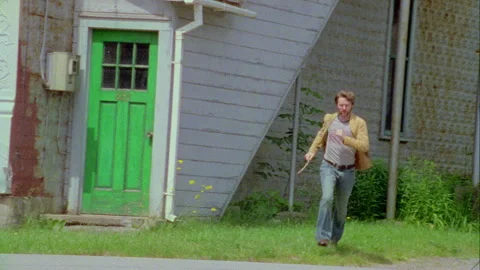 A young man runs outside a store in on old town, Monticello, NY 1989. Stock Footage 272250861