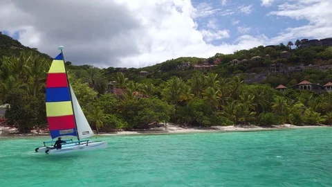 Young man sailing a catamaran at Cinnamon Bay Beach, St John 動画素材 70992172