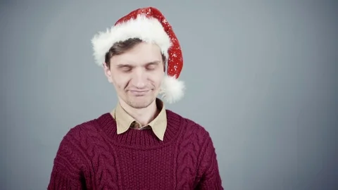 Young man in Santa hat opening a gift box with a surprise inside seeing Stock Footage 70261026
