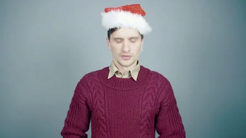 Young man in santa hat unsuccessfully juggles with Christmas decorations Video stock 70263552