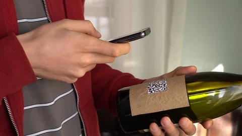 Young man scanning a QR code on wine label Stock Footage 103074937