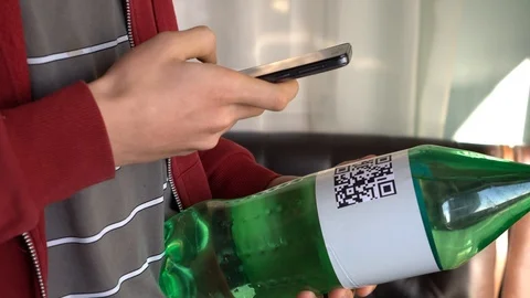Young man scanning a QR code on water packaging Stock Footage 103075009