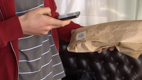 Young man scanning a QR code on food packaging Stock Footage 103075024