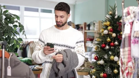 Young man scanning qr code of sweater in store Stock Footage 343165353