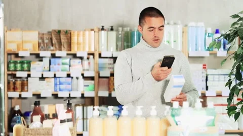 Young man scanning qr code of cream Stock Footage 347257224