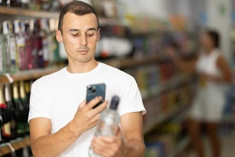 Young man scanning qr code for vodka Stock Photos