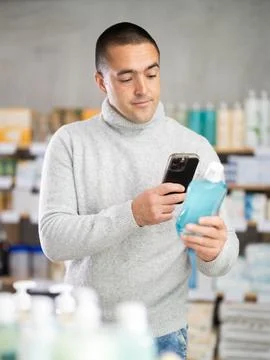 Young man scanning qr code of mouthwash Stock Photos